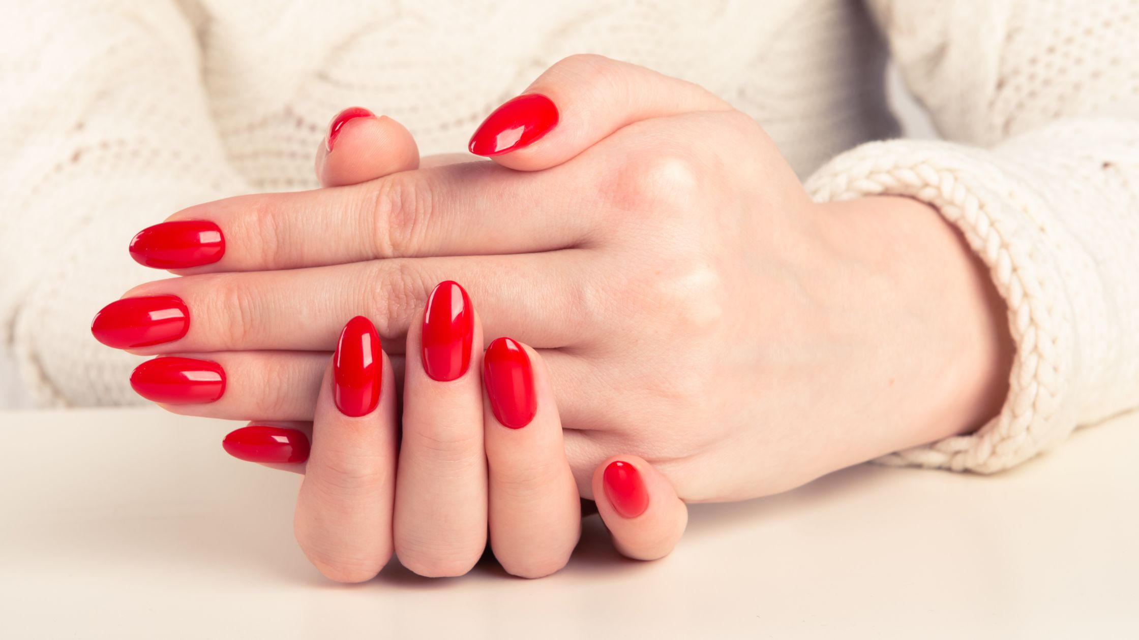 La mani di una donna con smalto rosso che ha fatto la manicure russa.